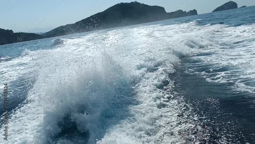 vague à l'arrière d'un bateau naviguant au bord des côtes
