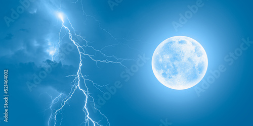 Lightning strikes between blue stormy clouds with full moon "Elements of this image furnished by NASA" 