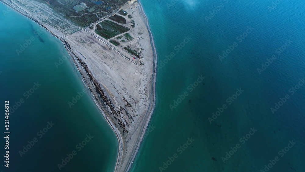 Aerial view of bright turquoise water and wild beach. Shot. Top view of the sandy sea coast and green meadow in a sunny day.