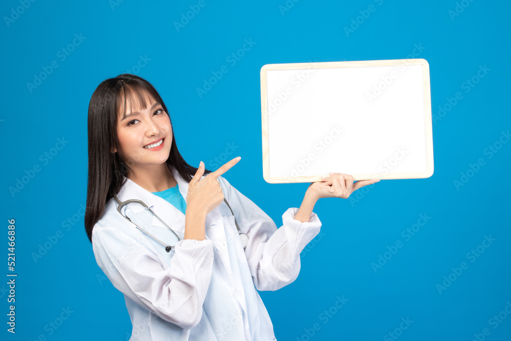 Smiling doctor holding blank banner or card with stethoscope on blue background Smiling doctor holding blank banner or card with stethoscope on blue background