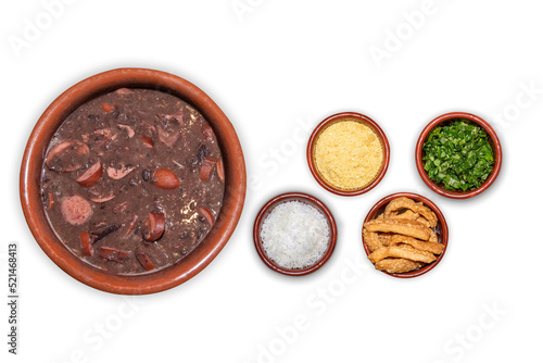 Delicious feijoada bowl with side dishes. Brazilian typical cuisine made with black beans and pork on white isolated background.