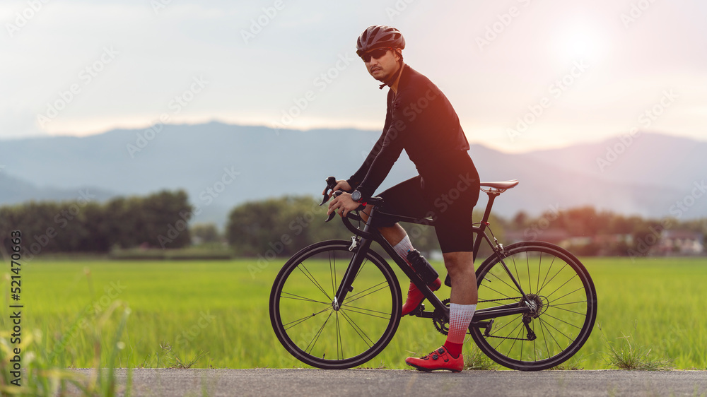 Fototapeta premium professional cyclist in cycling training suit against green nature blur background Healthy fitness and lifestyle concepts 