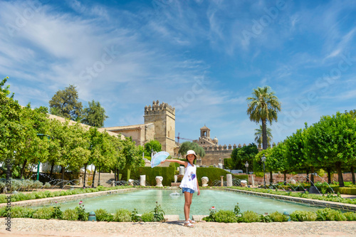 Gardens of the Alcazar de los Reyes Cristianos in Cordoba, Spain, posing Asian girl with a fan. photo