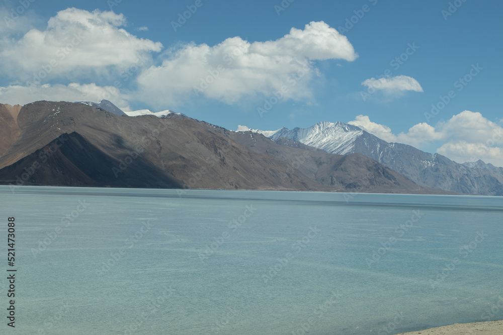Beautiful Scenery Of Pangong Tso Lake World's Highest Saltwater river Flowing Through The Great Himalayan Range With Dramatic Cloud In Blue Sky. Most Popular Tourist Destination Ladakh And Leh India