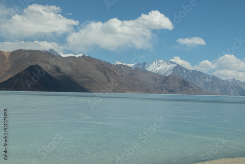 Beautiful Scenery Of Pangong Tso Lake World's Highest Saltwater river Flowing Through The Great Himalayan Range With Dramatic Cloud In Blue Sky. Most Popular Tourist Destination Ladakh And Leh India