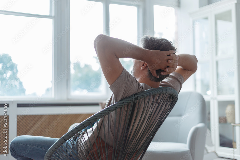 man sitting in a chair and looking out the window .