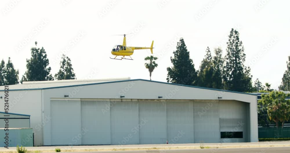 Panning A Small Yellow Helicopter As It Approaches Van Nuys Airport - Los Angeles, California