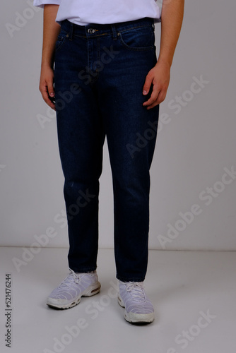 slender man in spring street clothes: skinny blue jeans and a white T-shirt. body parts: elastic male ass. concept: men's health and hemorrhoid pain. image for clothing catalog