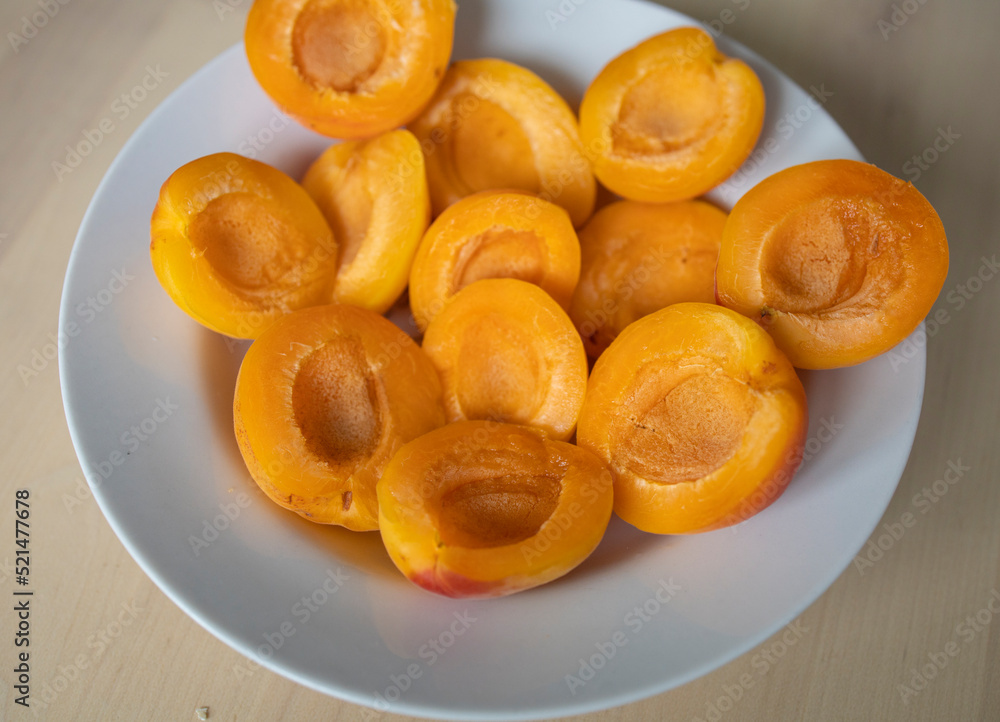 ripe, juicy apricots lie on a white plate. Energy boost, vitamins, ripe fruits, pesticides. Interruptions in the supply of fruits, imports of apricots