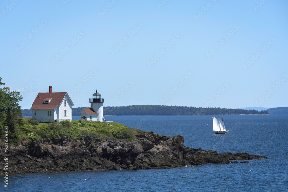 Curtis Island lighthouse and ship sailing by in Camden, Maine.