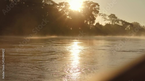 Salida del sol en río Madre de Dios, Perú photo