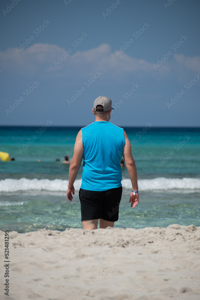 young man on the beach with his back turned on a summer's day
