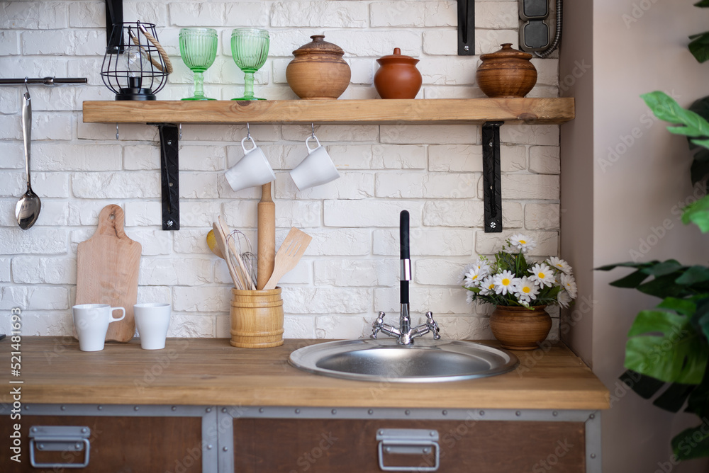 The picture shows the kitchen interior. Kitchen table, pots, a kettle, ladles and other various utensils. Background for recipes. The picture shows the kitchen interior. Kitchen table, pots, a kettle, ladles and other various utensils. Background for recipes.