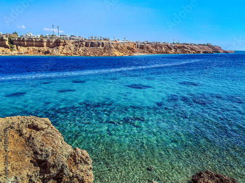 Top view from the cliff to the Red Sea in the Sharm el-Maya bay in Sharm El Sheikh, Egypt. Amazing seascape with azure water against desert cityscape