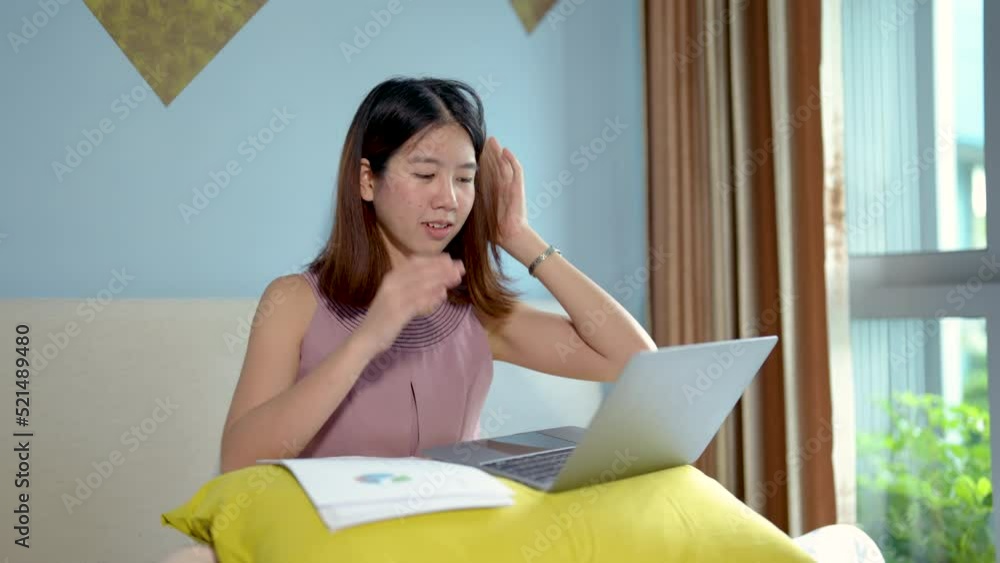 4K, Asian teenage girls are stressed about online classes having to figure out a job in order to send teacher in bed. woman sits in a hotel room using a laptop computer on vacation. work from anywhere 4K, Asian teenage girls are stressed about online classes having to figure out a job in order to send teacher in bed. woman sits in a hotel room using a laptop computer on vacation. work from anywhere