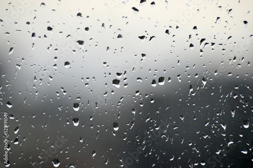 Abstract photo background. Rain drops on window. Selective focus, rainy city background. Water drops on glass. Rainy weather, blur wallpaper. 