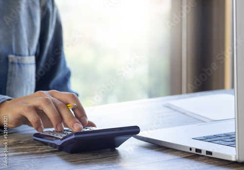 Hand on calculator at home office table