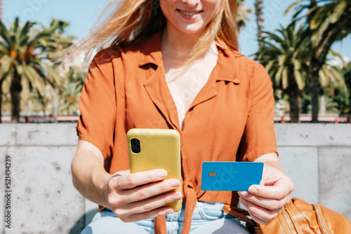 unrecognizable caucasian woman holding smart phone and credit card. Concept of online shopping photo