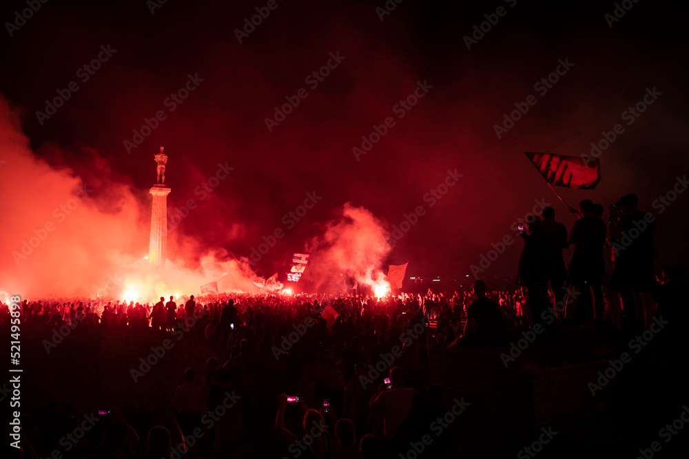 Red Star Football fans with torches and flags celebrating league title win next to monument Pobednik in Belgrade, Serbia 22.05.2022