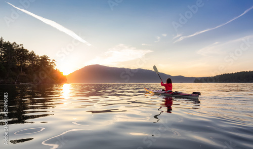 Adventurous Woman on Sea Kayak paddling in the Pacific Ocean. Sunny Summer Sunset. Taken near Victoria, Vancouver Islands, British Columbia, Canada. Concept: Sport, Adventure © edb3_16