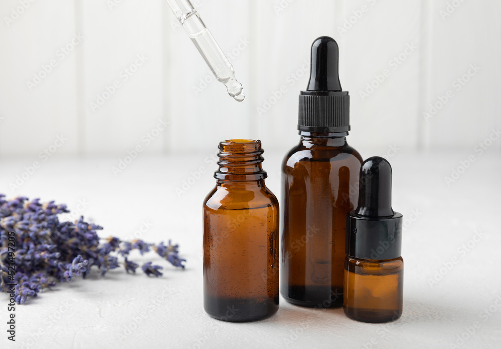 Essential oil of lavender on a white texture background. Spa concept. RELAX. Bottle with fragrant oil and lavender flowers.Aromatic oil with lavender scent.mockup of lavender essential oil.Copy space.