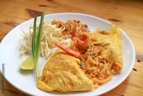 Plate of Pad Thai, Flavorful Thai Style Fried Noodle Wrapped in Fried Egg and Topped with Prawns