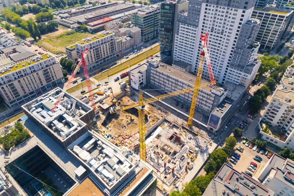 Professional construction site including several cranes working on a building complex. Future apartments in the process of building. High quality photo