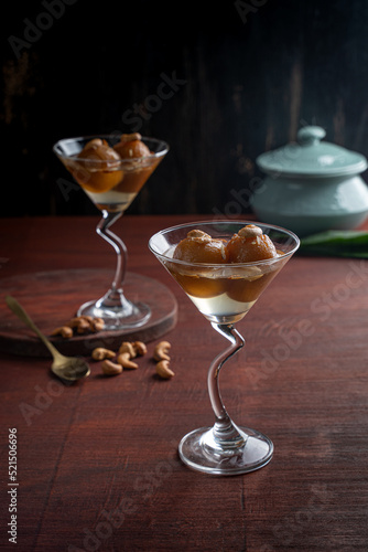 Indian sweet Gulab Jamun with almond and cashew nut served in a goblets isolated on dark background side view of fastfood