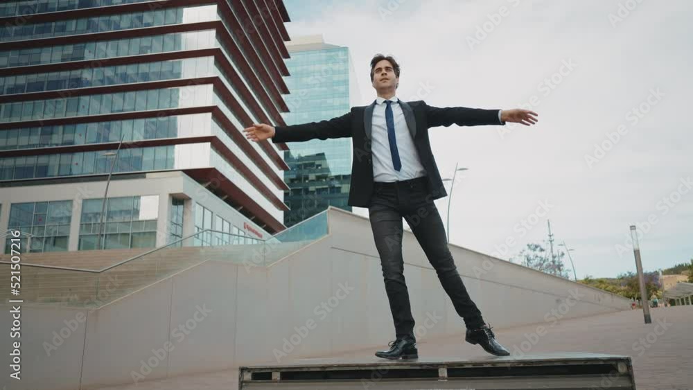 Flexible and cool businessman doing acrobatic tricks outdoor. Young business man having fun dancing while going to work.