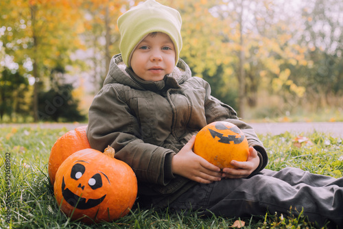 A boy with a Halloween pumpkin with eyes . The feast of fear. Halloween. An orange pumpkin with eyes. © alenka2194
