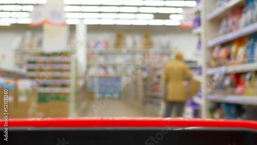Wallpaper Mural Blurred view from a supermarket trolley moving between rows of groceries and unrecognizable shoppers. Consumption of food and buying it in the supermarket using a basket for convenience. Torontodigital.ca