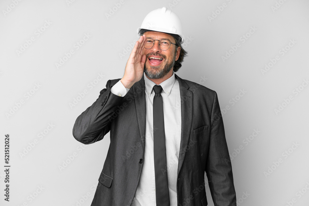Young architect man with helmet over isolated background shouting with mouth wide open Young architect man with helmet over isolated background shouting with mouth wide open