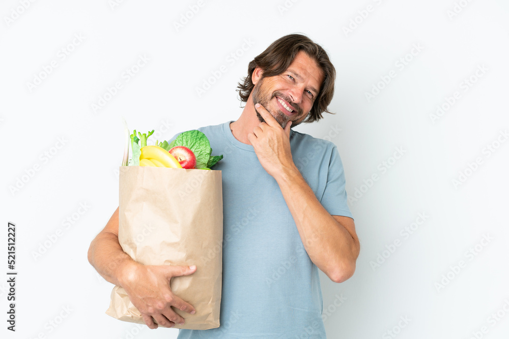 Senior dutch man holding grocery shopping bag over isolated background happy and smiling Senior dutch man holding grocery shopping bag over isolated background happy and smiling