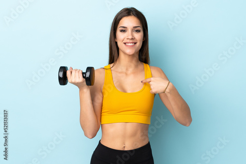 Young caucasian woman making weightlifting isolated on blue background with surprise facial expression