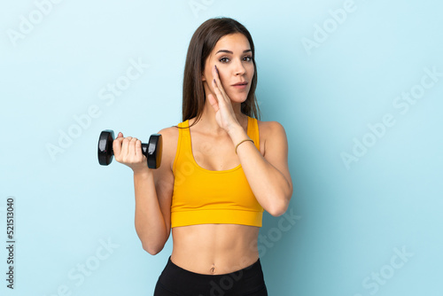 Young caucasian woman making weightlifting isolated on blue background whispering something © luismolinero