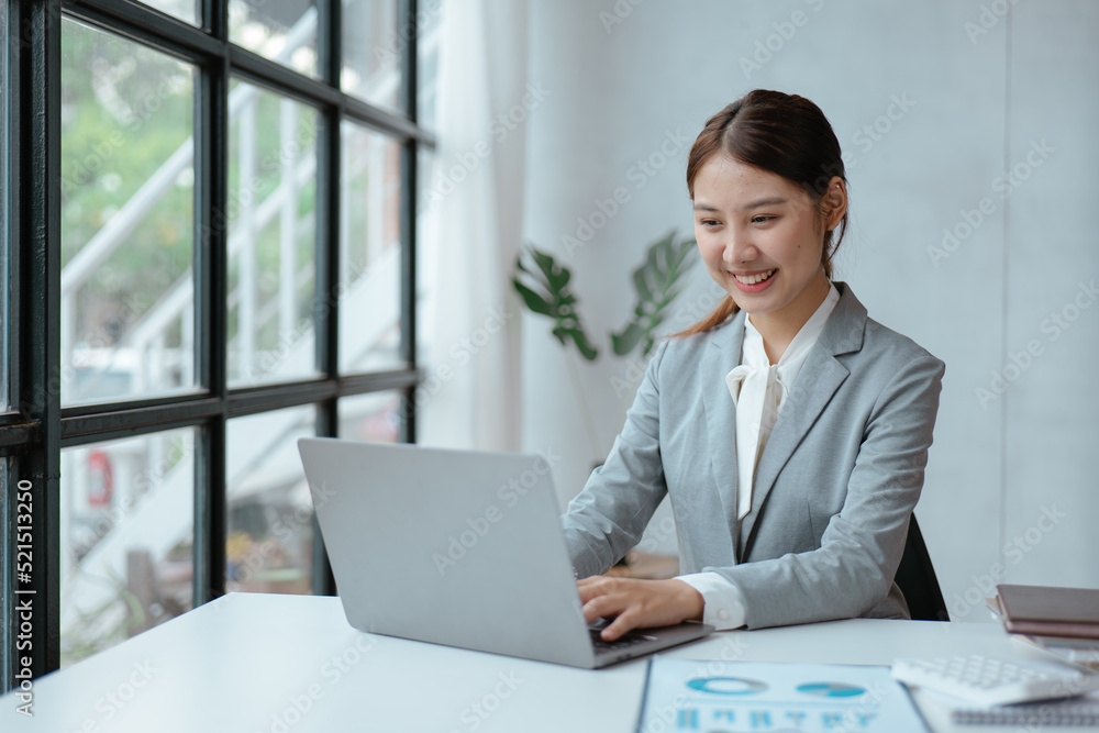 Young business women working and typing on laptop with happy and smile face on office spec. Young business women working and typing on laptop with happy and smile face on office spec.
