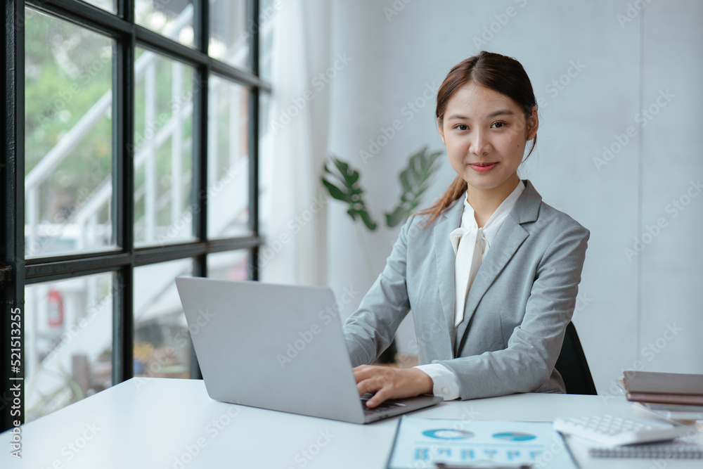 Young business women working and typing on laptop with happy and smile face on office spec. Young business women working and typing on laptop with happy and smile face on office spec.