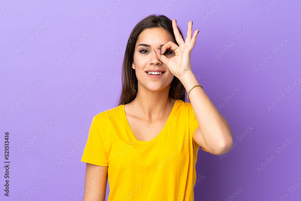 Fototapeta premium Young caucasian woman over isolated background showing ok sign with fingers