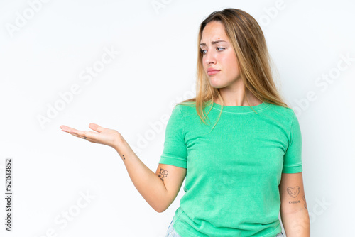Young caucasian woman isolated on white background holding copyspace with doubts