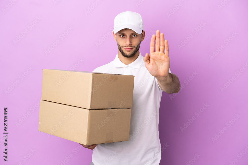 Delivery caucasian man isolated on purple background making stop gesture Delivery caucasian man isolated on purple background making stop gesture