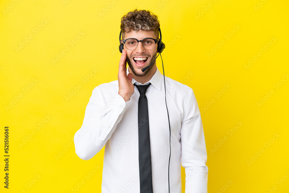 Telemarketer blonde man working with a headset isolated on yellow background with surprise and shocked facial expression Telemarketer blonde man working with a headset isolated on yellow background with surprise and shocked facial expression