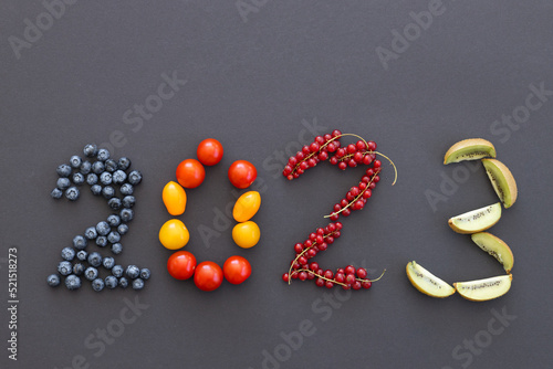 Happy New Year 2023 number made of fruits and berries on black