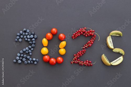 Happy New Year 2025 number made of fruits and berries on black