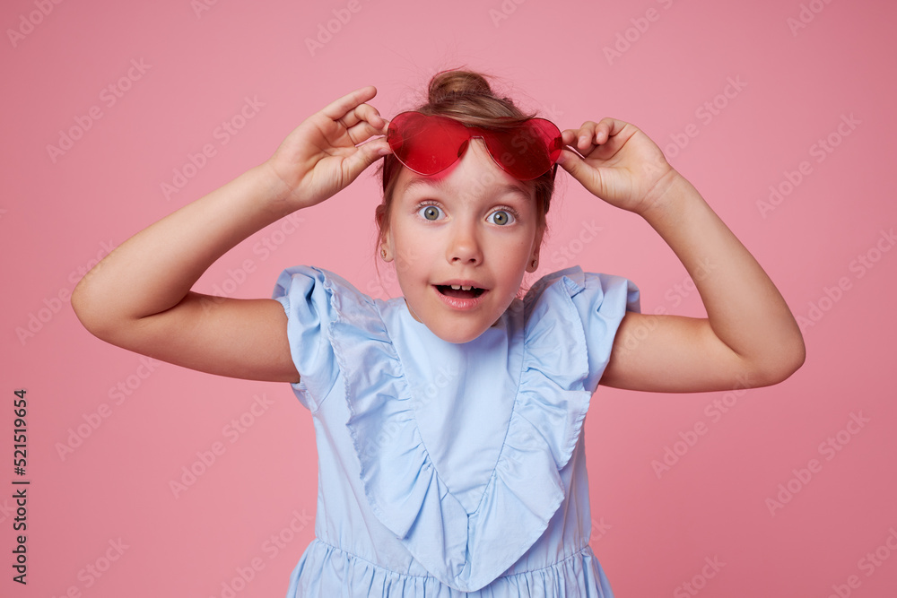 Portrait of surprised cute toddler girl in the heart shape sunglasses. Child with open mouth having fun isolated over pink background. Looking at camera. Wow funny face. Portrait of surprised cute toddler girl in the heart shape sunglasses. Child with open mouth having fun isolated over pink background. Looking at camera. Wow funny face.