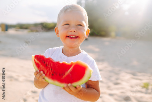Funny kid eating watermelon outdoors.  Child, baby, healthy food. Youth lifestyle. Happiness, joy, holiday, beach, summer concept.