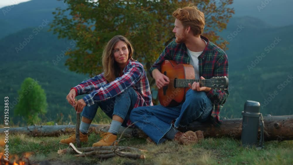 Closeup couple travelers relax on mountains trip. Campers enjoy romantic music. Closeup couple travelers relax on mountains trip. Campers enjoy romantic music.