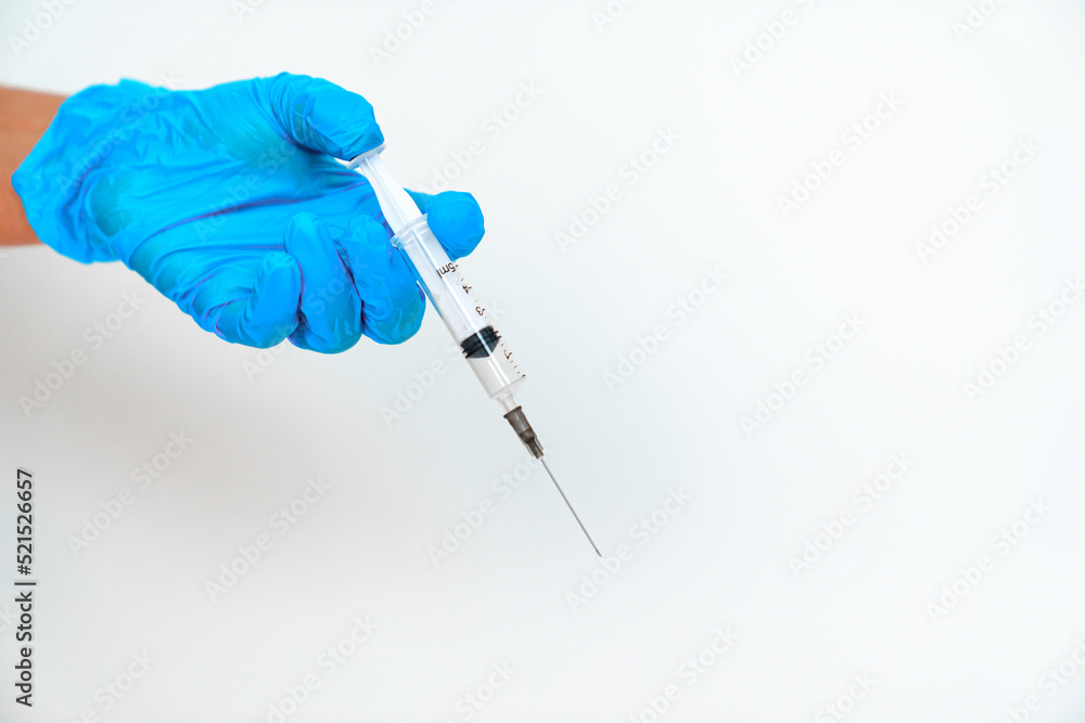 women's hands in blue gloves with a disposable syringe. women's hands in blue gloves with a disposable syringe.