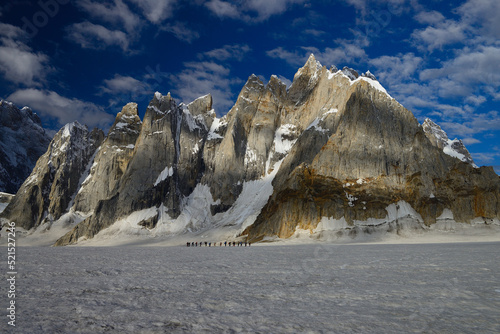 A wide-angle shot of An Australian expedition led by porters moving towards snow lake while crossing Mount Sosbun Brakk  6413m  on Biafo Glacier in Pakistan.