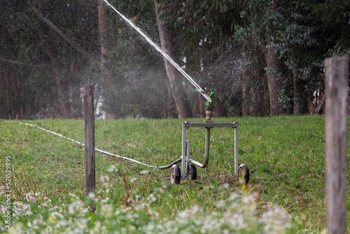 water sprinklers turned on in a farm field, agriculture and nature care, environment on farm in the day