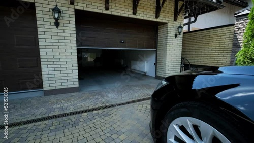 Man driver in car thumbed remote control to open the garage door in the house photo